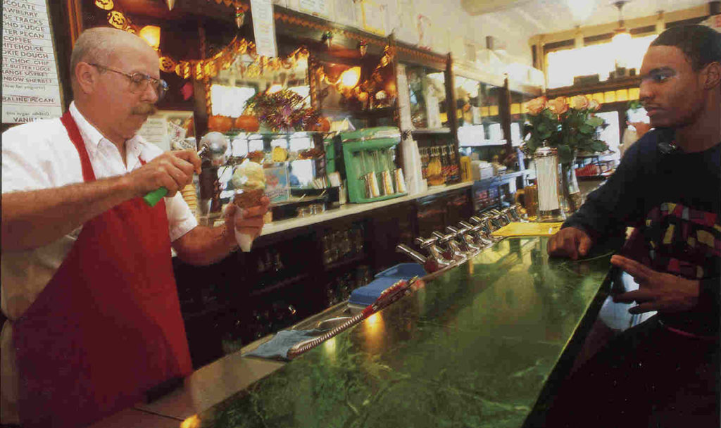 Ray Klavon scoops ice cream for an eager customer.